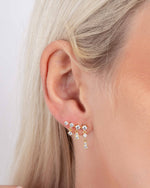 Close up of models ear wearing cubic zirconia gold diamond earrings with an ear climber design 