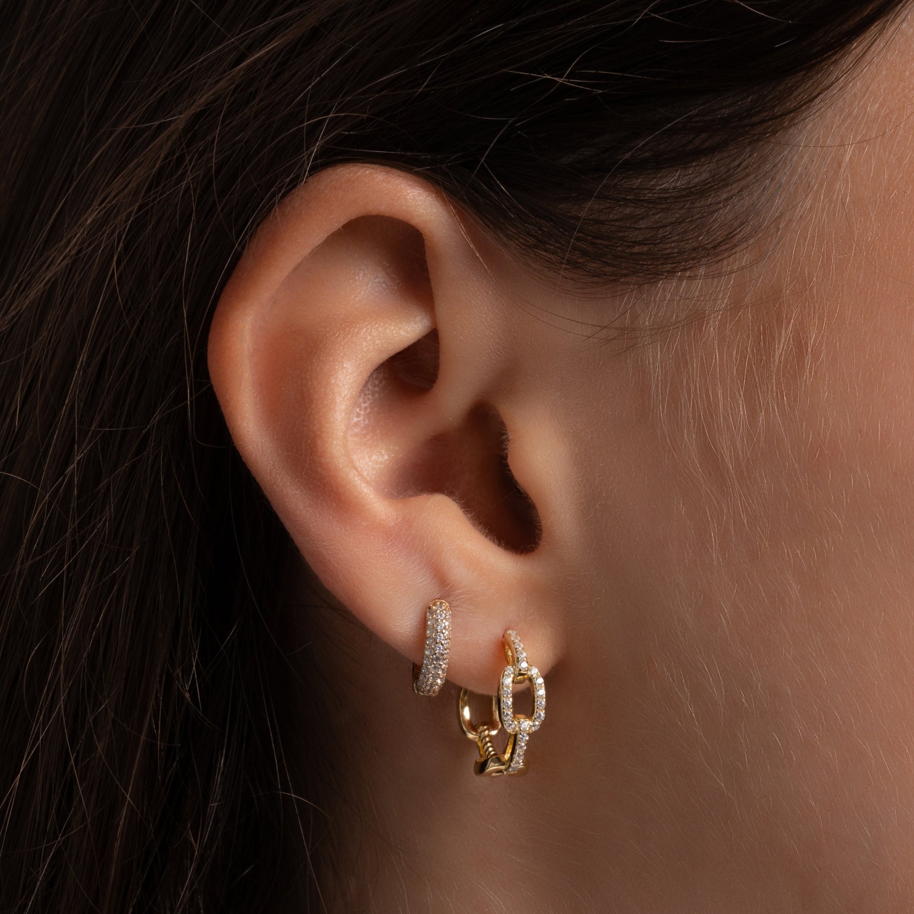 model wearing delicate gold hoops featuring small hoop earrings 