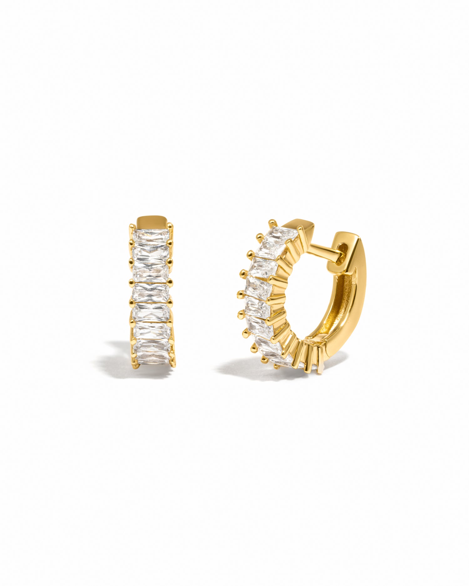 Gold baguette hoop earrings with white cubic zirconia gemstones on a white background
