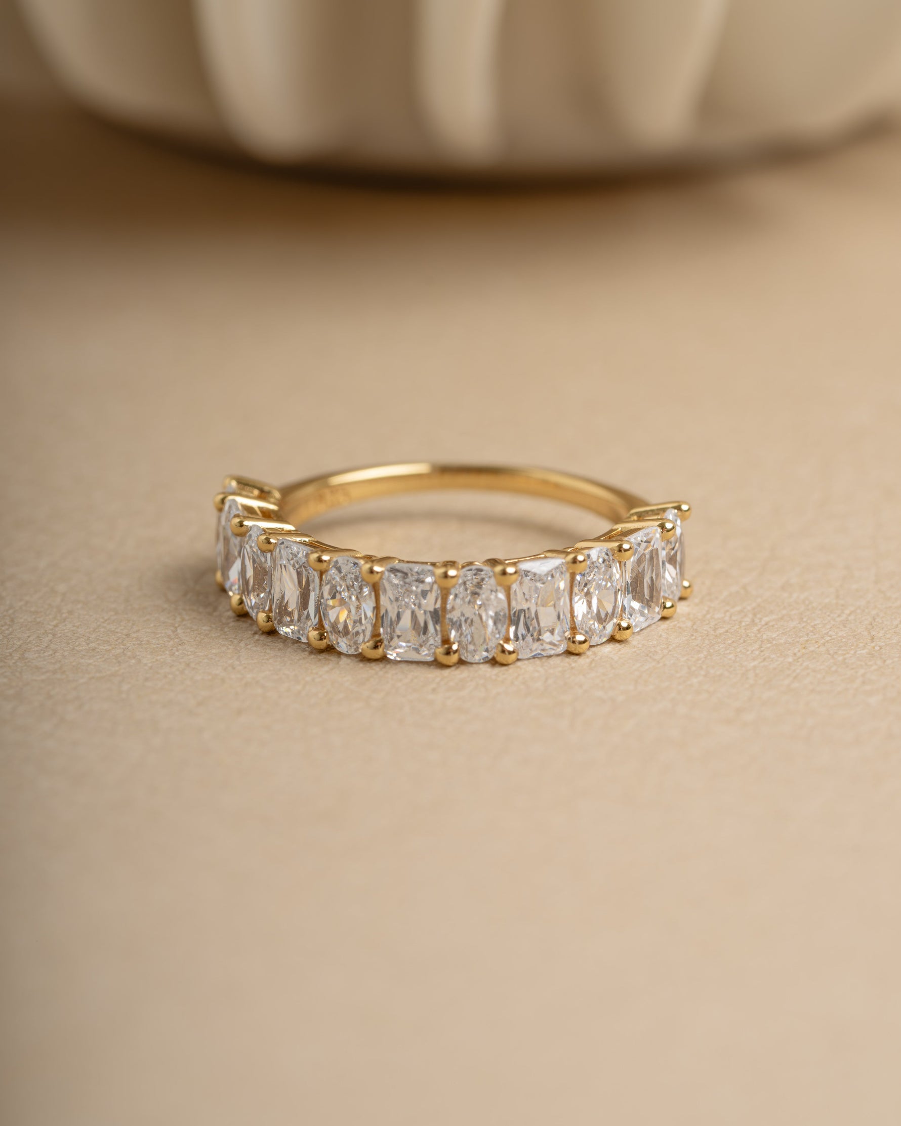 Gold diamond gemstone ring on beige background