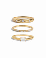Three gold rings with diamond accents on a white background
