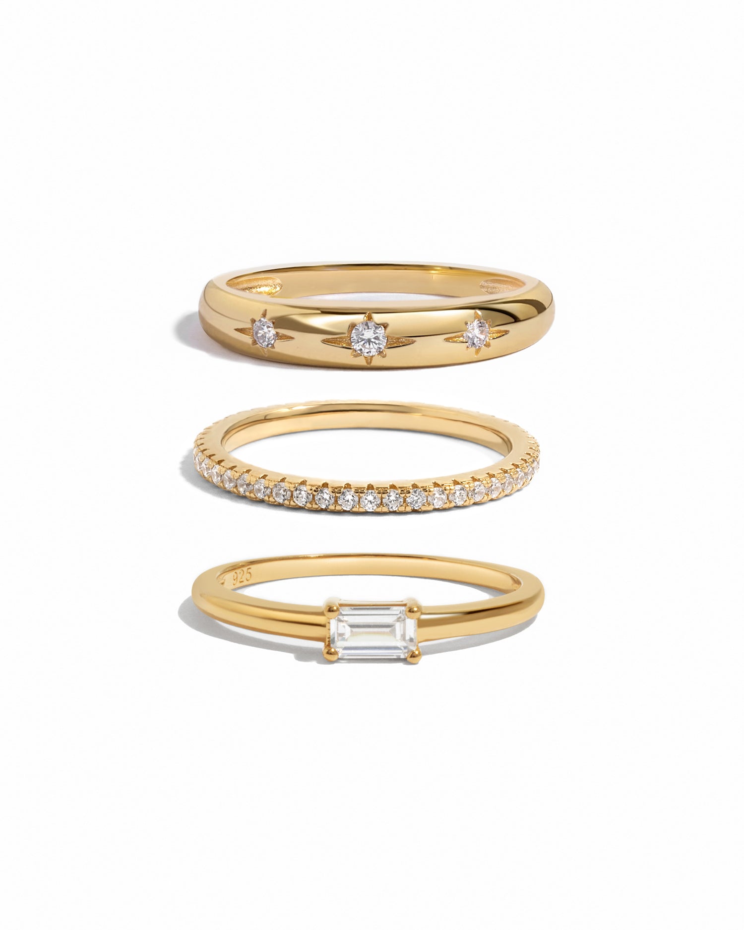 Three gold rings with diamond accents on a white background