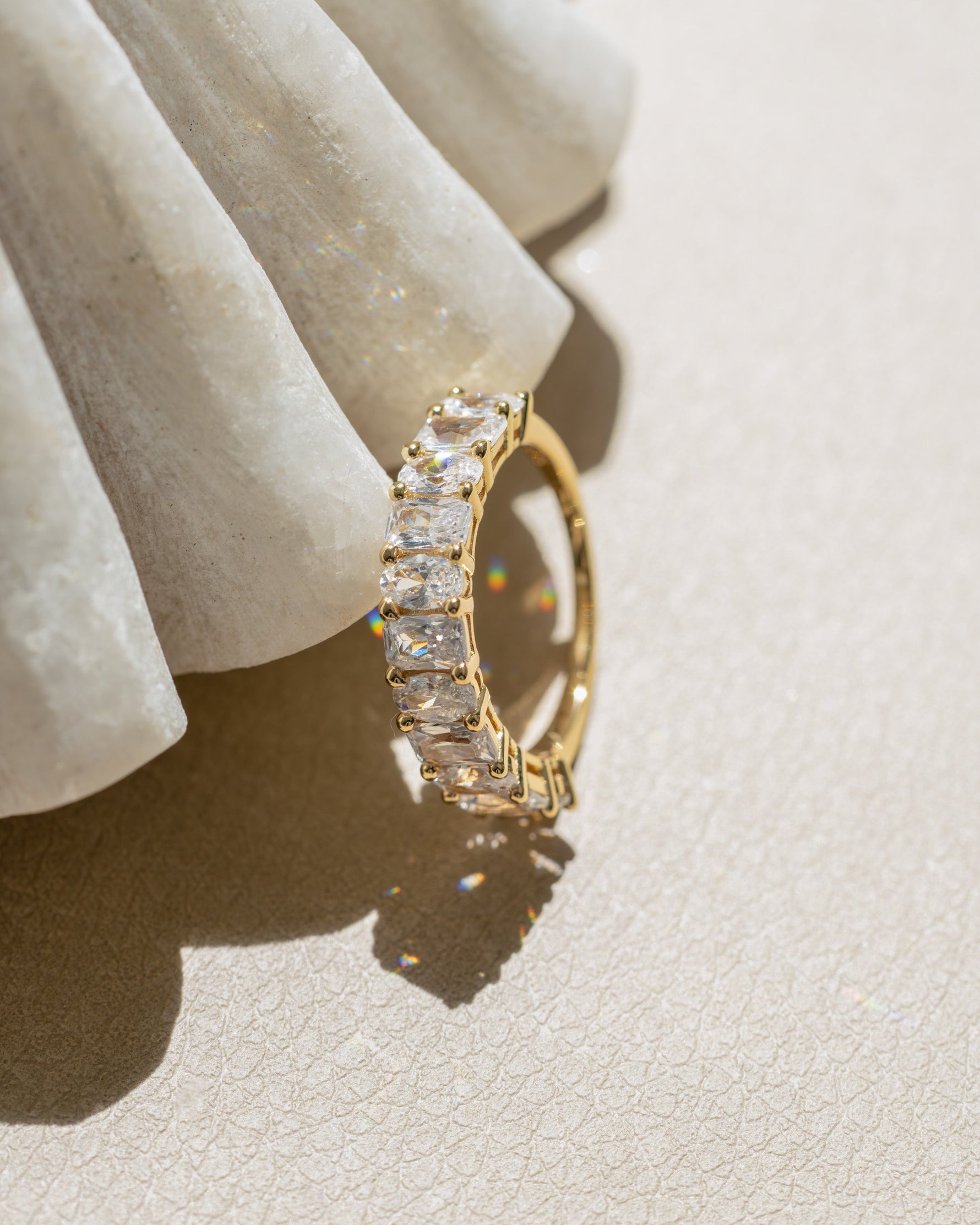 Gold cubic zirconia wedding ring on a textured surface