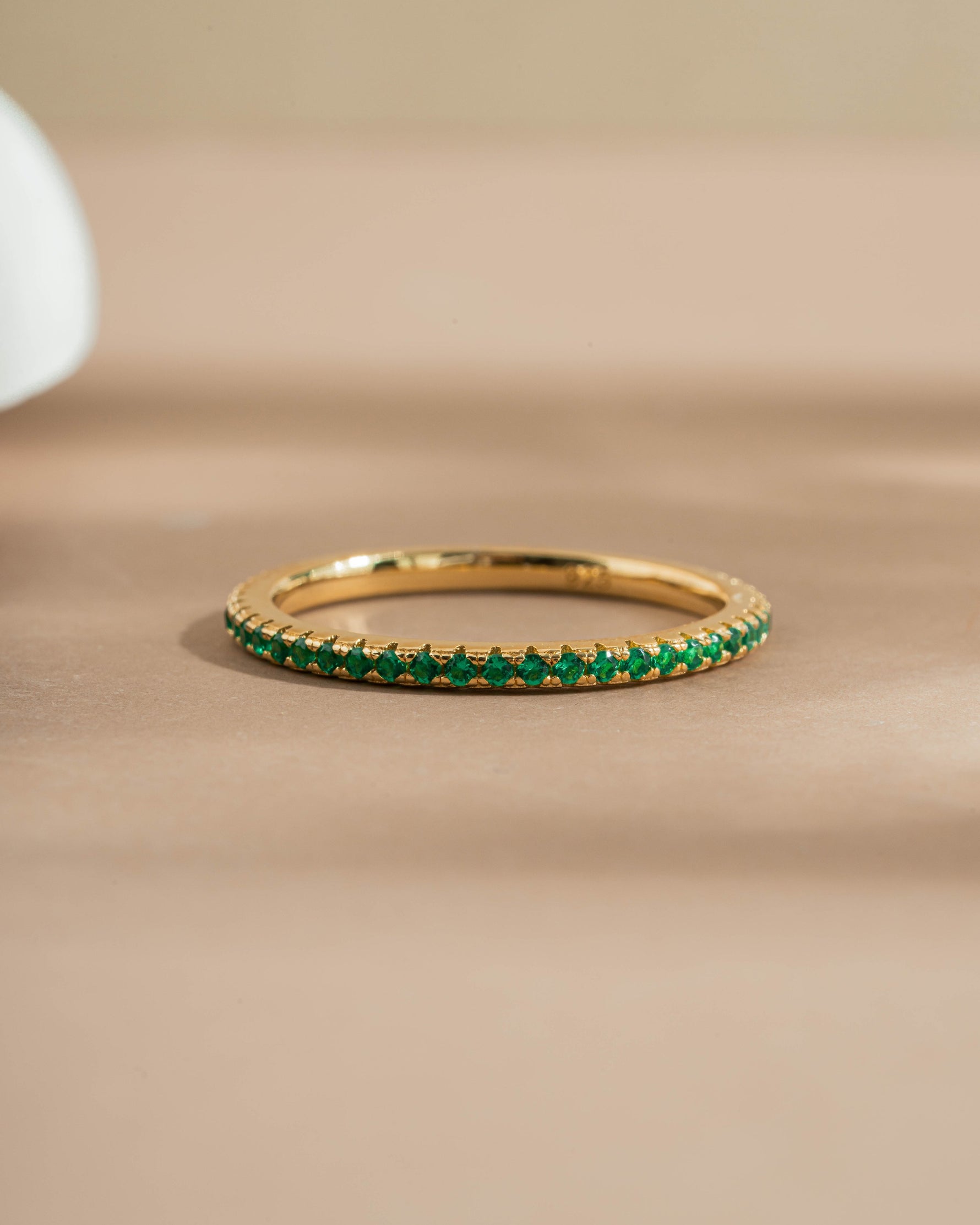 Gold eternity band on beige background