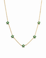 Gold necklace with emerald flower charms on a simple chain