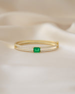 Gold vintage bracelet featuring a diamond bangle design and emerald birthstone