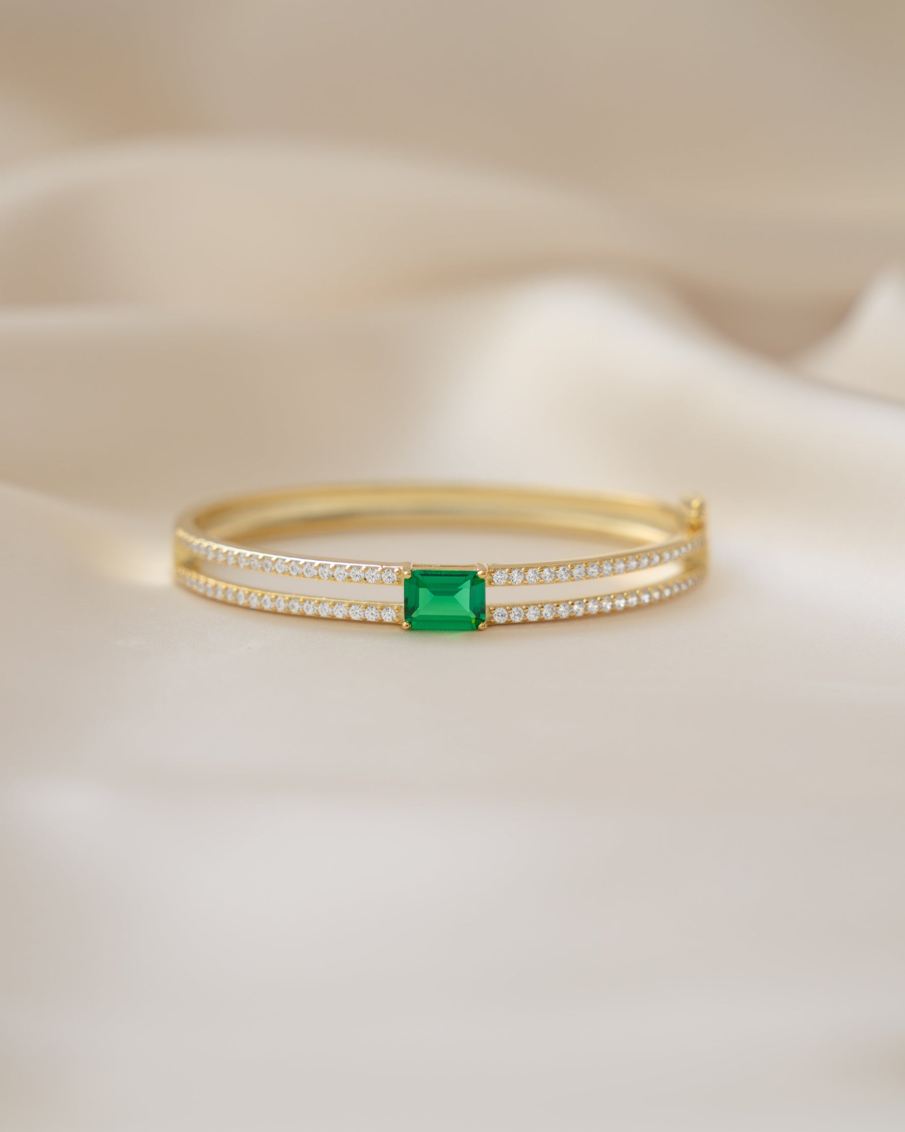 Gold vintage bracelet featuring a diamond bangle design and emerald birthstone