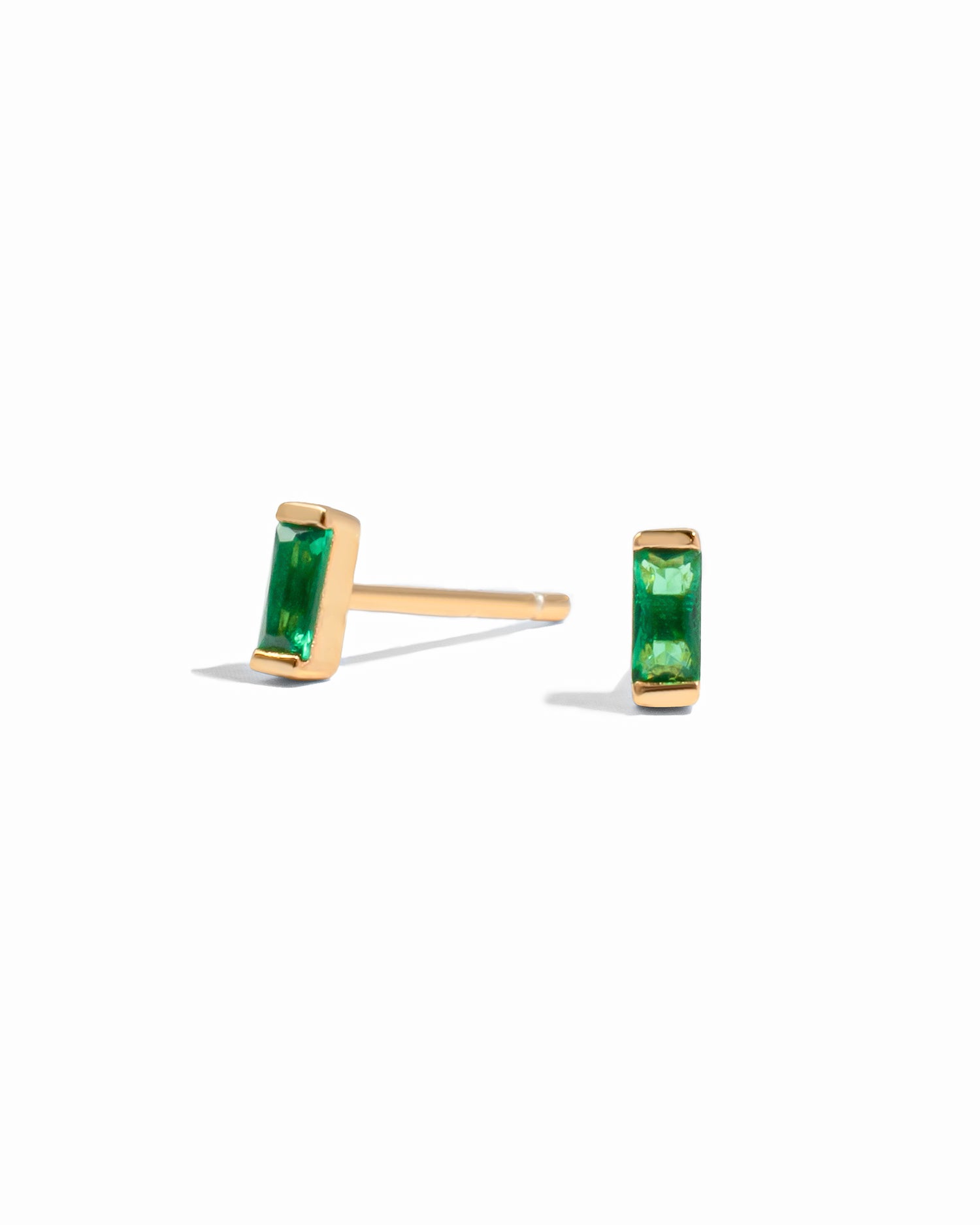 Emerald birthstone earrings on a white background