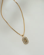 Gold chain custom necklace with a custom pendant "S" on a plain background 