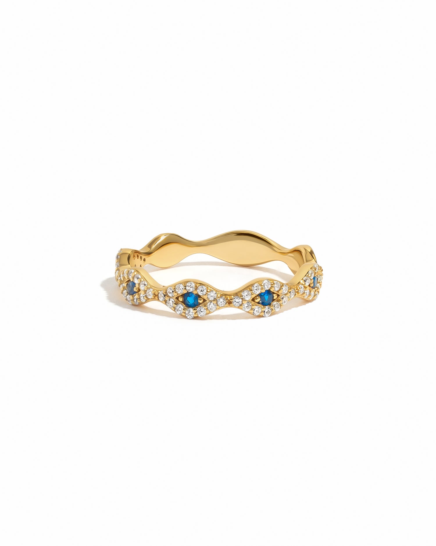 Gold evil eye ring with blue gemstones on a white background