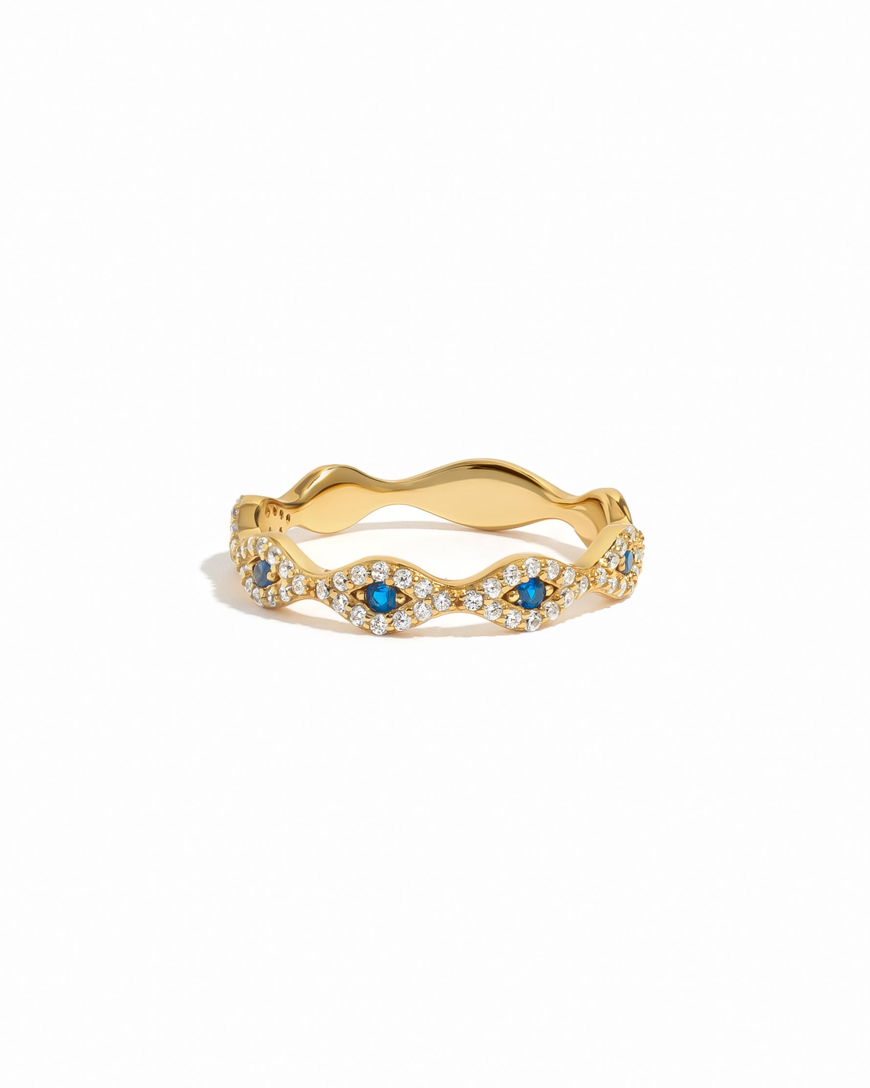 Gold evil eye ring with blue gemstones on a white background