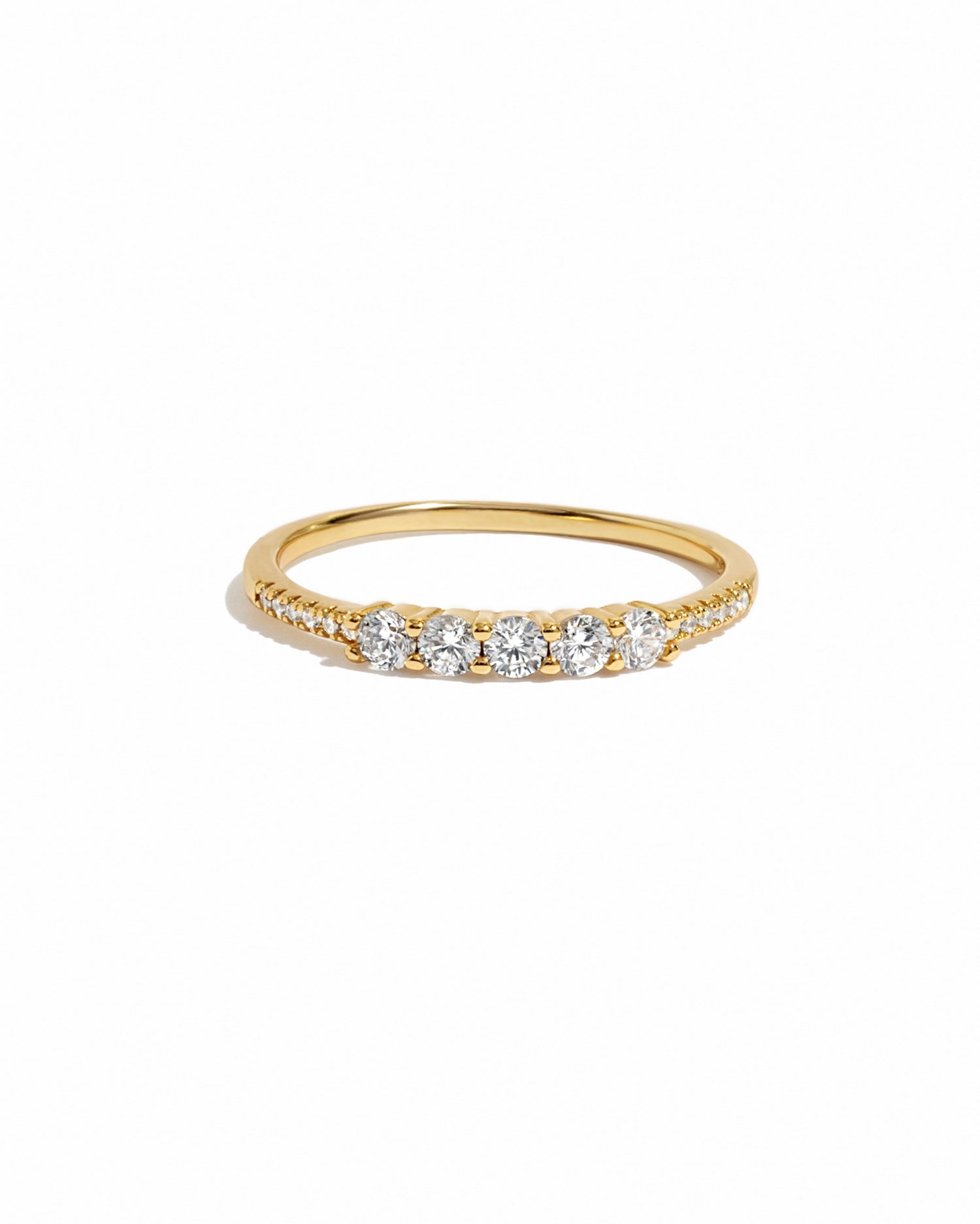 Gold ring with five cubic zirconia stones and smaller pave stones on a gold band 