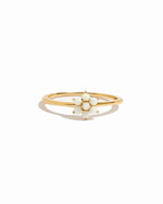 Gold dainty ring with a opal flower design on a white background