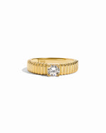flat lay of a fluted solitaire ring and its texture resembles the delicate pleats of fine fabric, giving it an artistic feel.