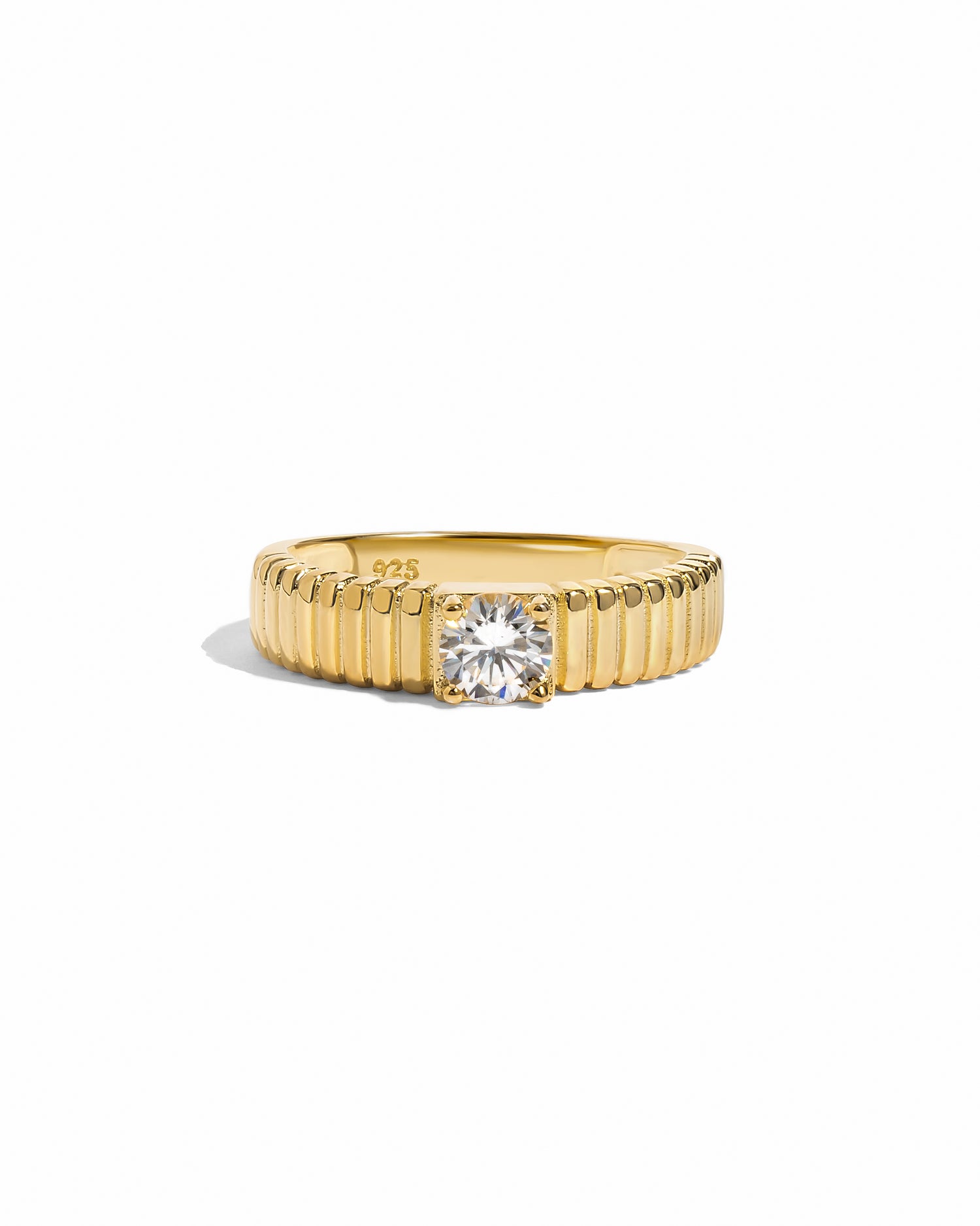 flat lay of a fluted solitaire ring and its texture resembles the delicate pleats of fine fabric, giving it an artistic feel.