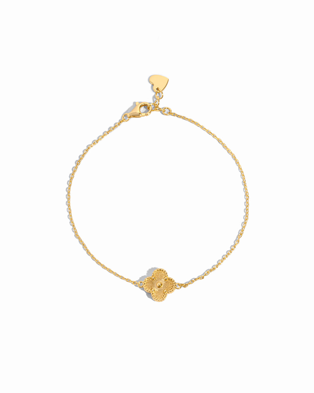 flat lay of a single charm four leaf clover charm bracelet with delicate gold chain on white background