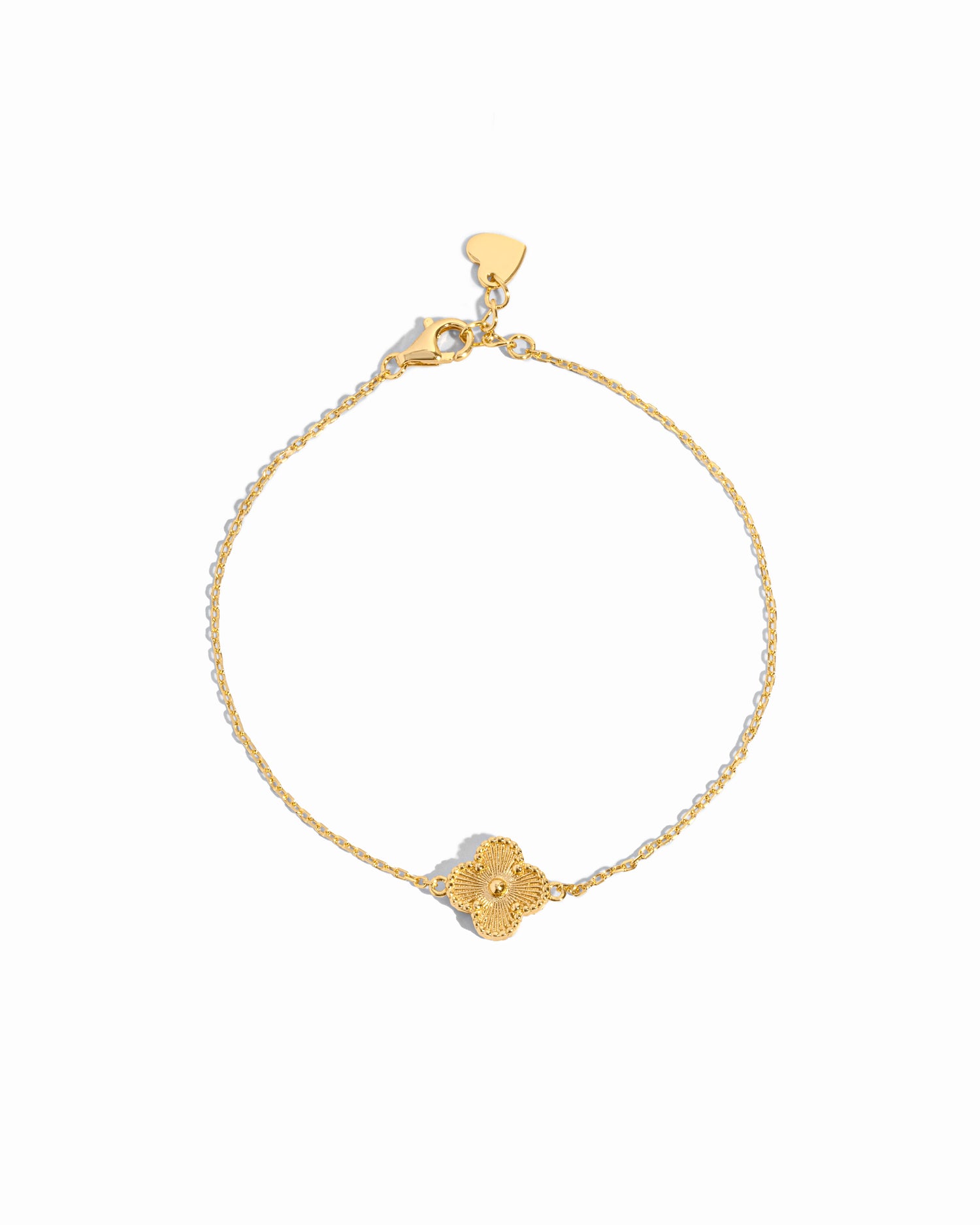 flat lay of a single charm four leaf clover charm bracelet with delicate gold chain on white background