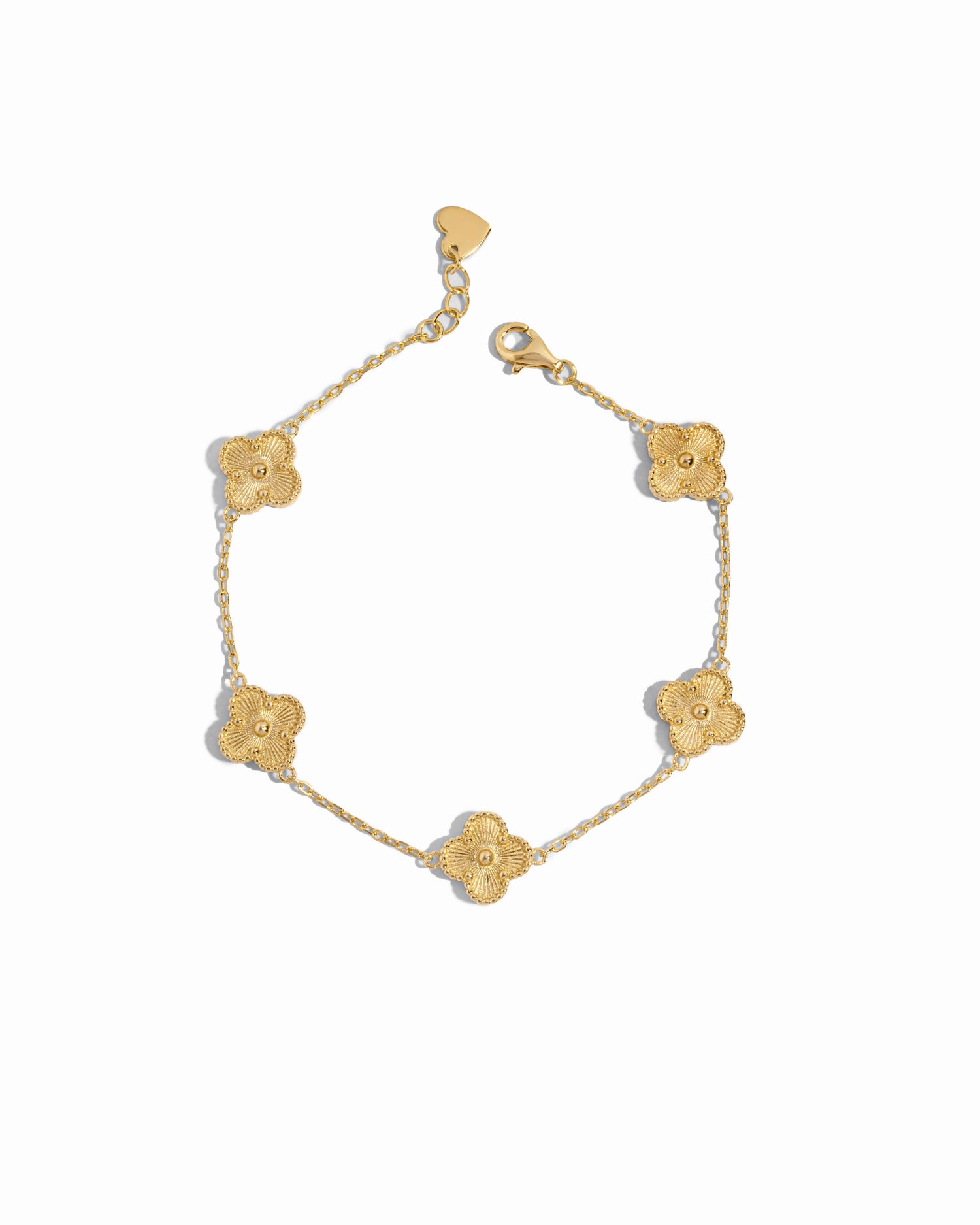 Close-up of a gold clover jewelry charm bracelet highlighting fine detailing on a white background