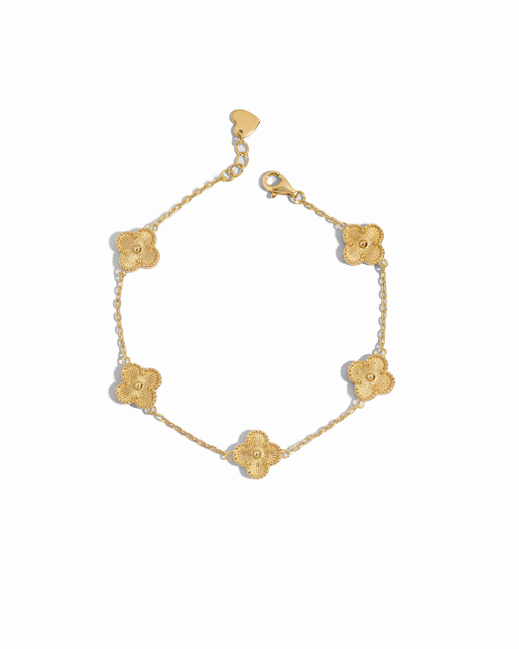 Close-up of a gold clover jewelry charm bracelet highlighting fine detailing on a white background