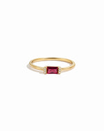 Gold diamond birthstone ring with garnet birthstone on a white background
