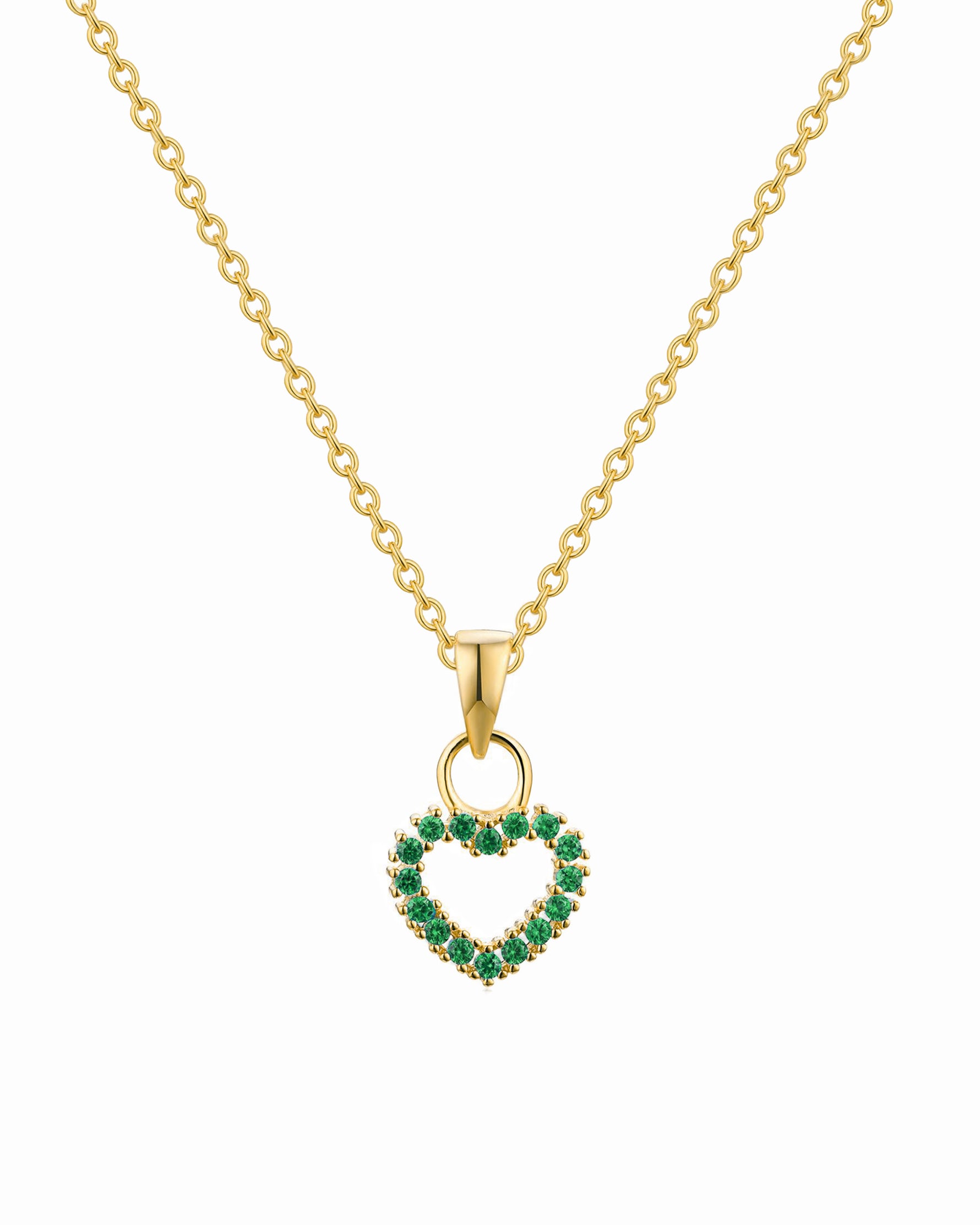 Gold necklace with a heart-shaped pendant featuring green gemstones on a white background