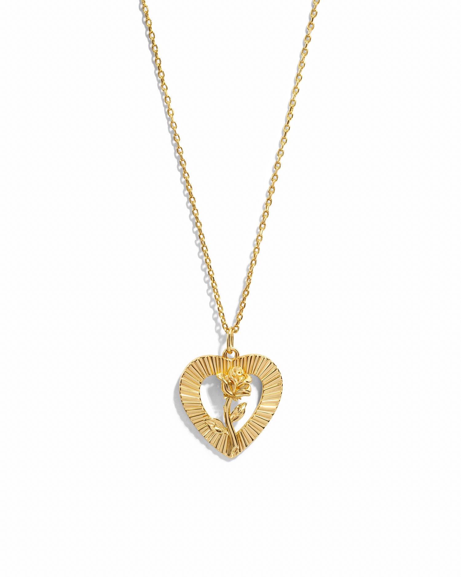 Gold rose necklace with heart pendant on white background