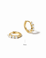 Gold small hoop earrings with gemstones on a white background