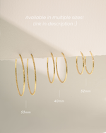 Diamond hoop earrings in three sizes, 32mm, 40mm, 53mm, these gold hoop statement earrings are displayed hanging off a paper to show the different variant sizing.