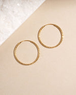 Overhead view of 32mm thin gold hoops, perfect everyday earrings with modern, minimalist design.
