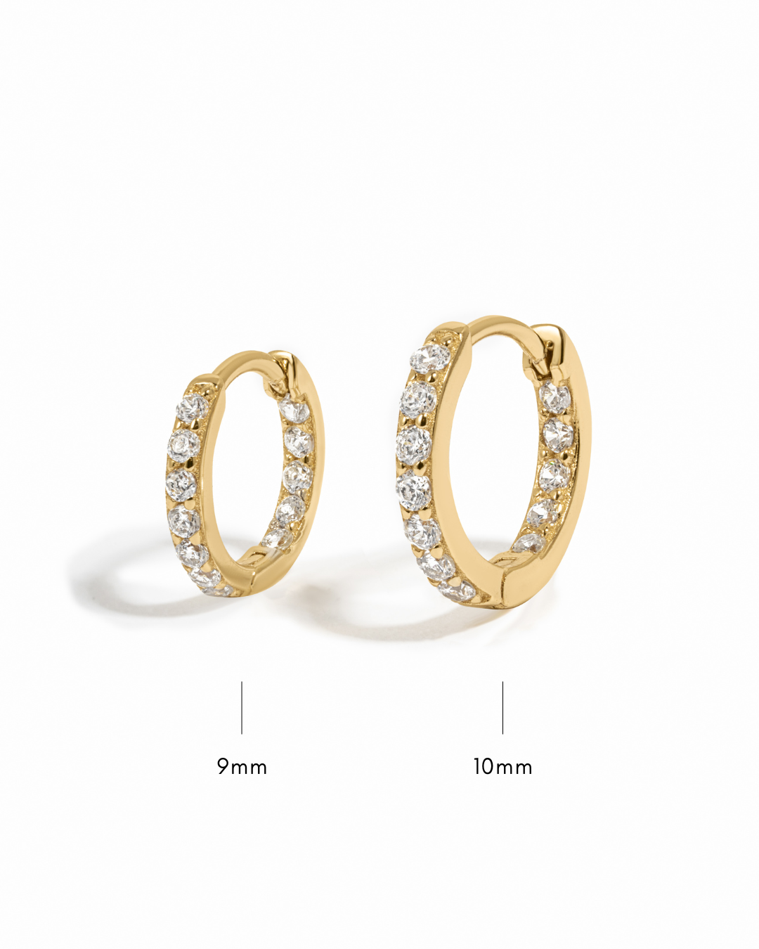 Gold hoop earrings with diamond accents and their sizes a white background