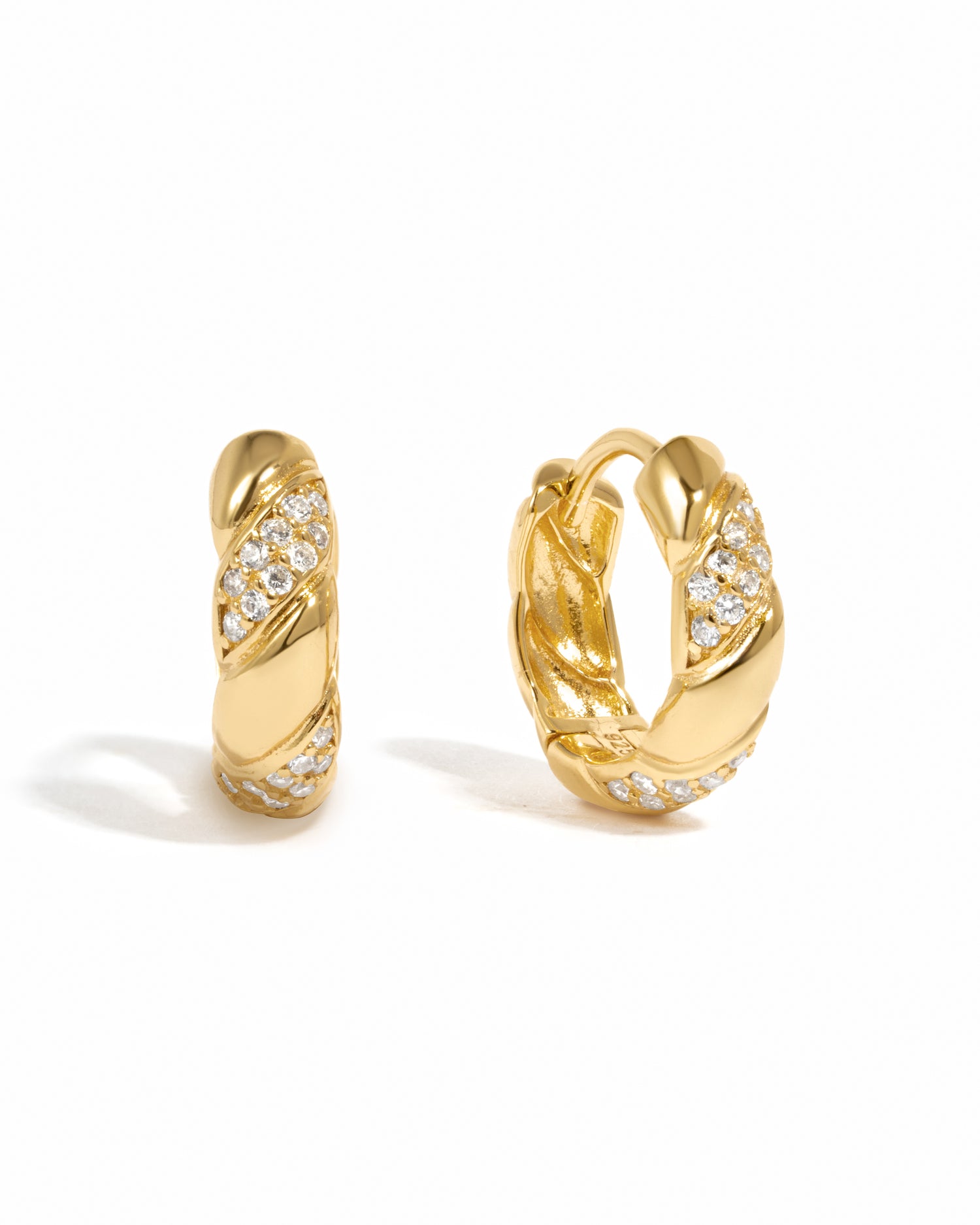 Gold hoop earrings with diamond accents on a white background