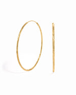 Gold statement earrings featuring diamond hoop earrings