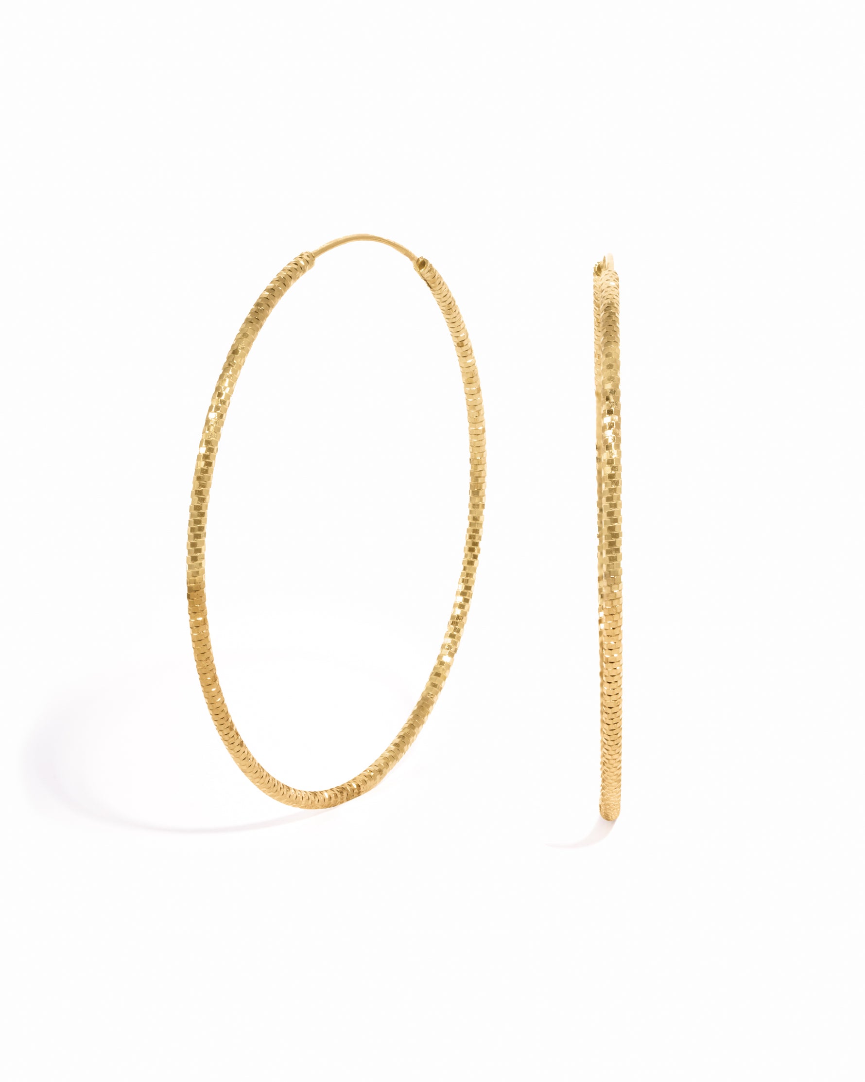 Gold statement earrings featuring diamond hoop earrings
