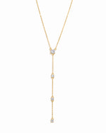 Gold lariat necklace on a white background