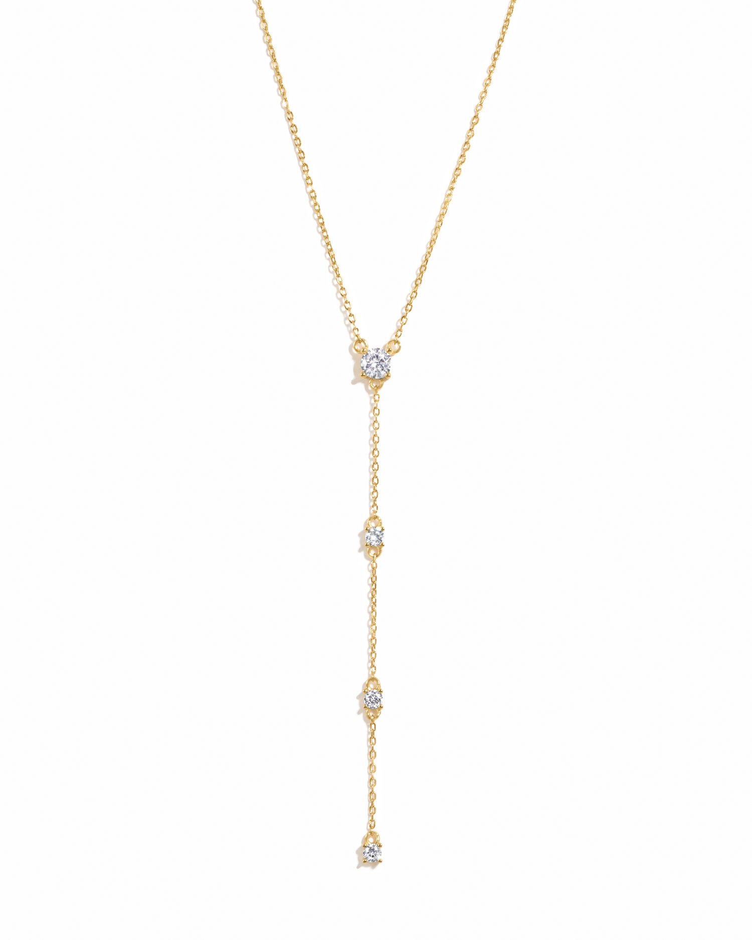 Gold lariat necklace on a white background