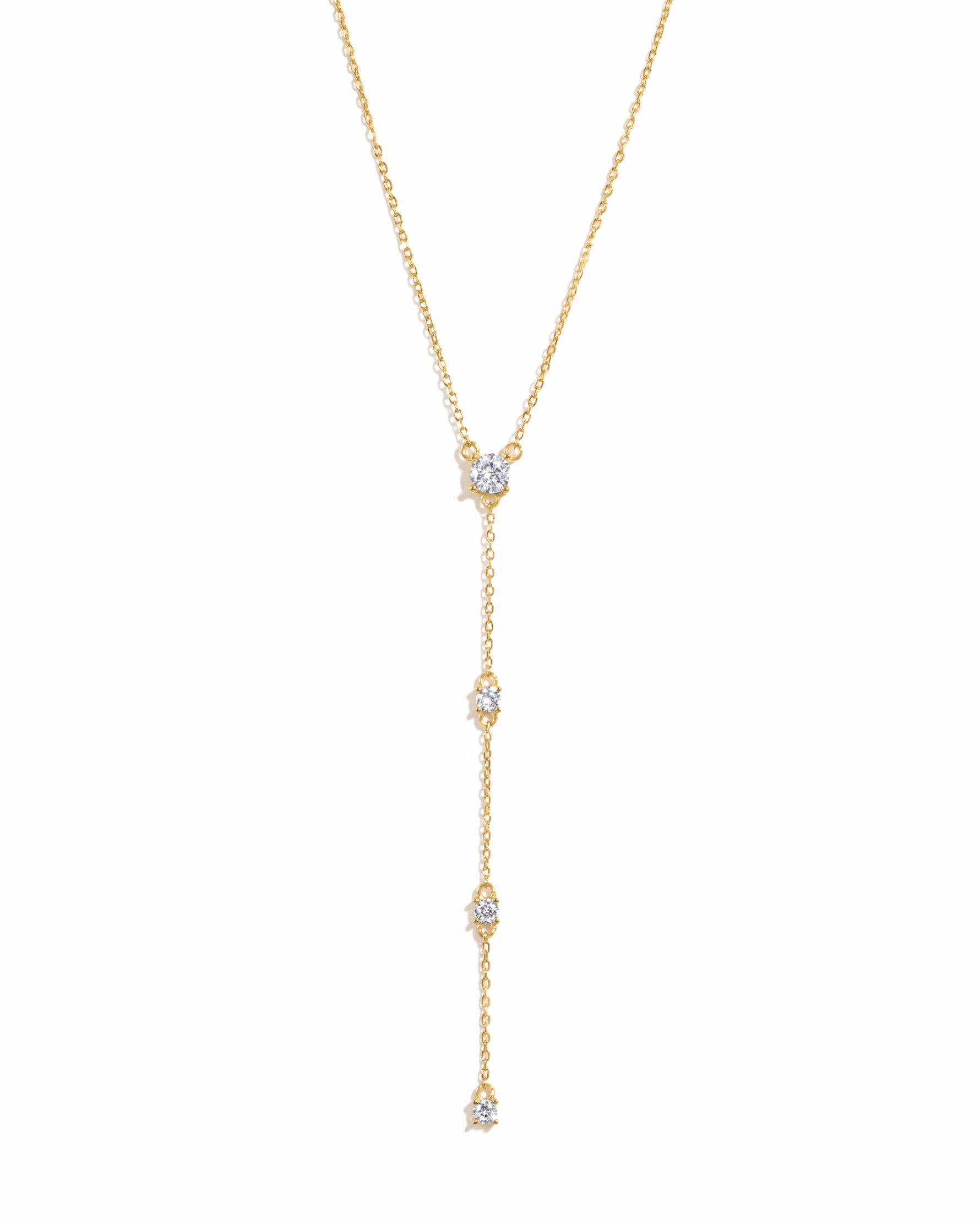 Gold lariat necklace on a white background