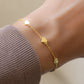 Close up of gold bracelet with heart charms styled solo on a wrist, ideal as gift for her or a romantic anniversary gift.