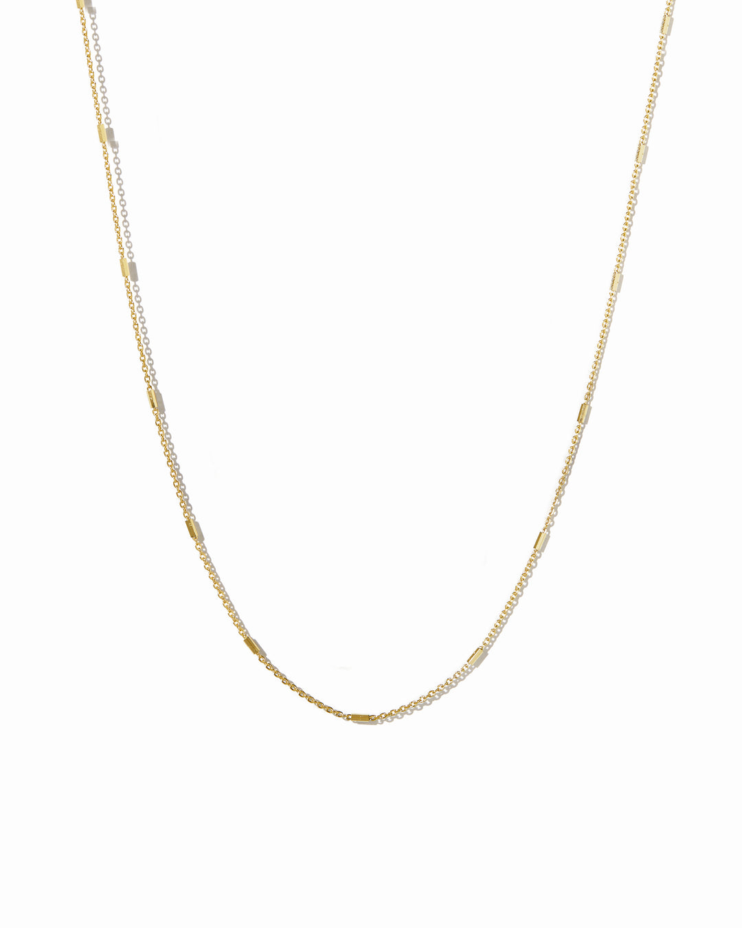 Gold dainty chain necklace on a white background