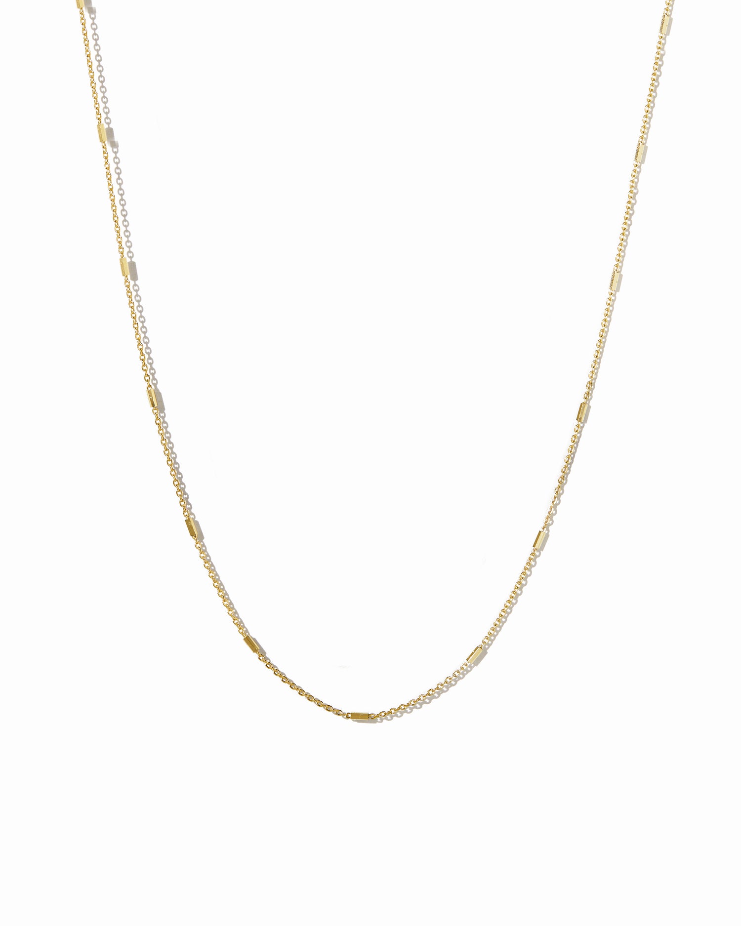 Gold dainty chain necklace on a white background