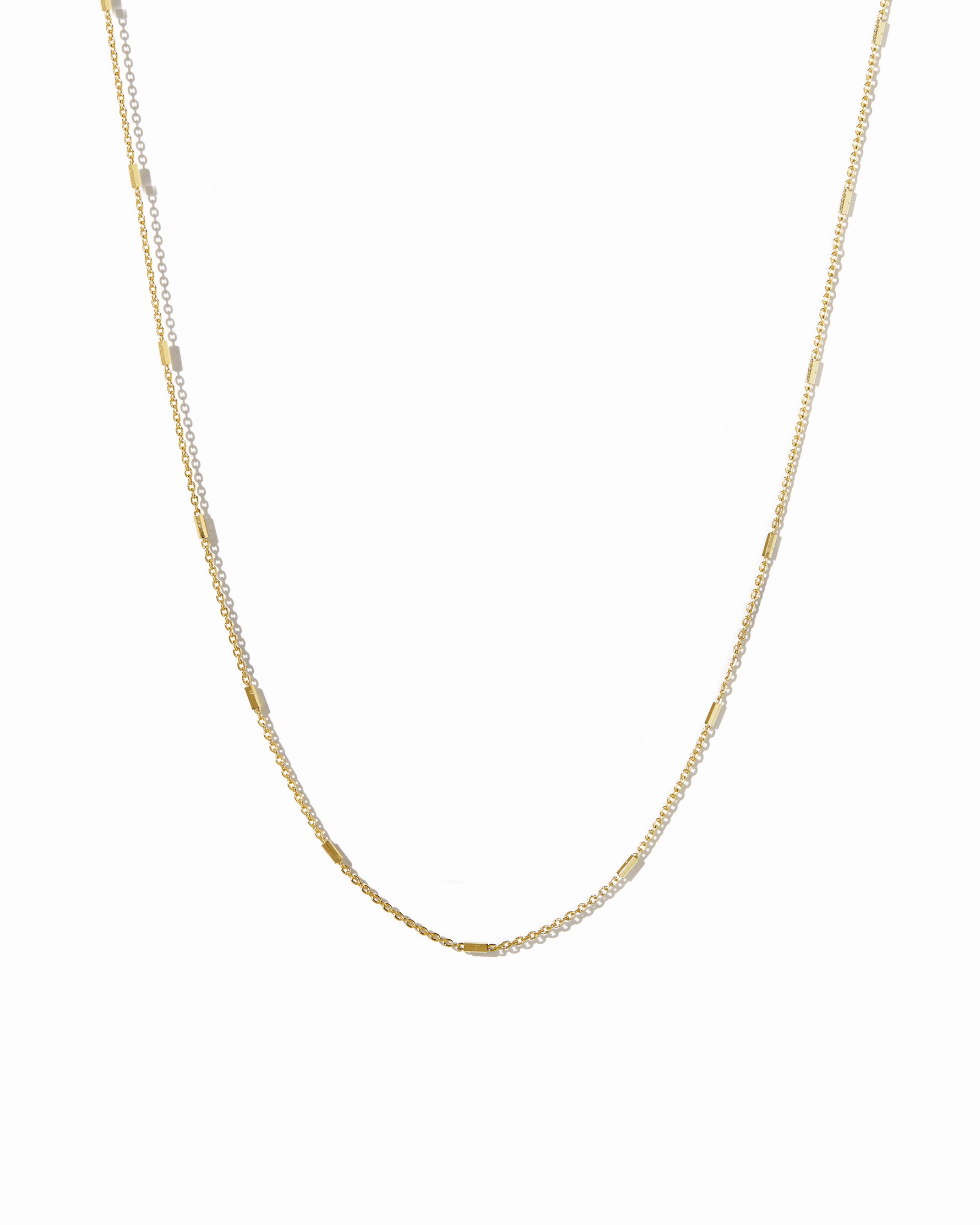 Gold dainty chain necklace on a white background
