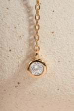Gold chain necklace with a bezel set diamond pendant