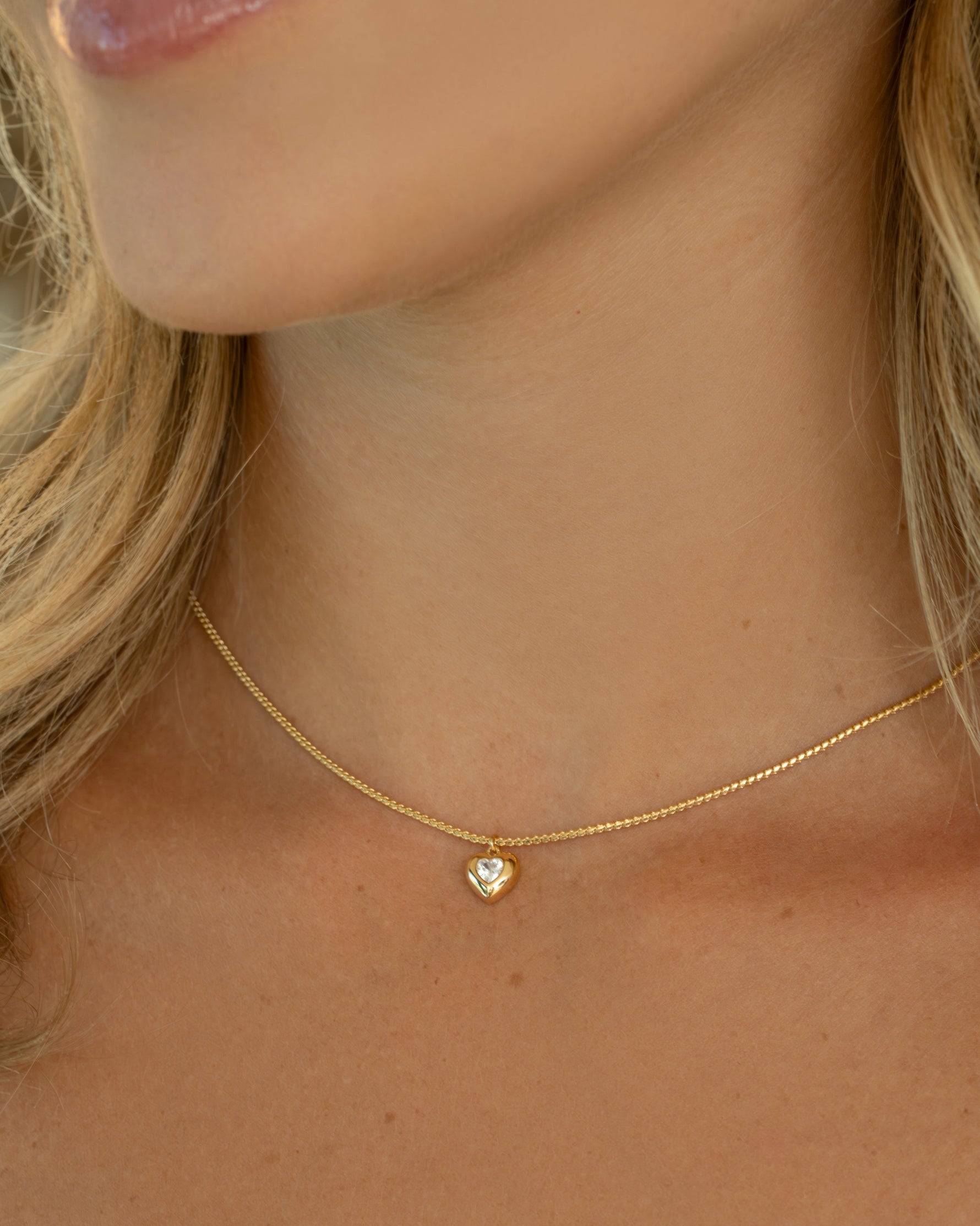 Gold chain with heart pendant on model