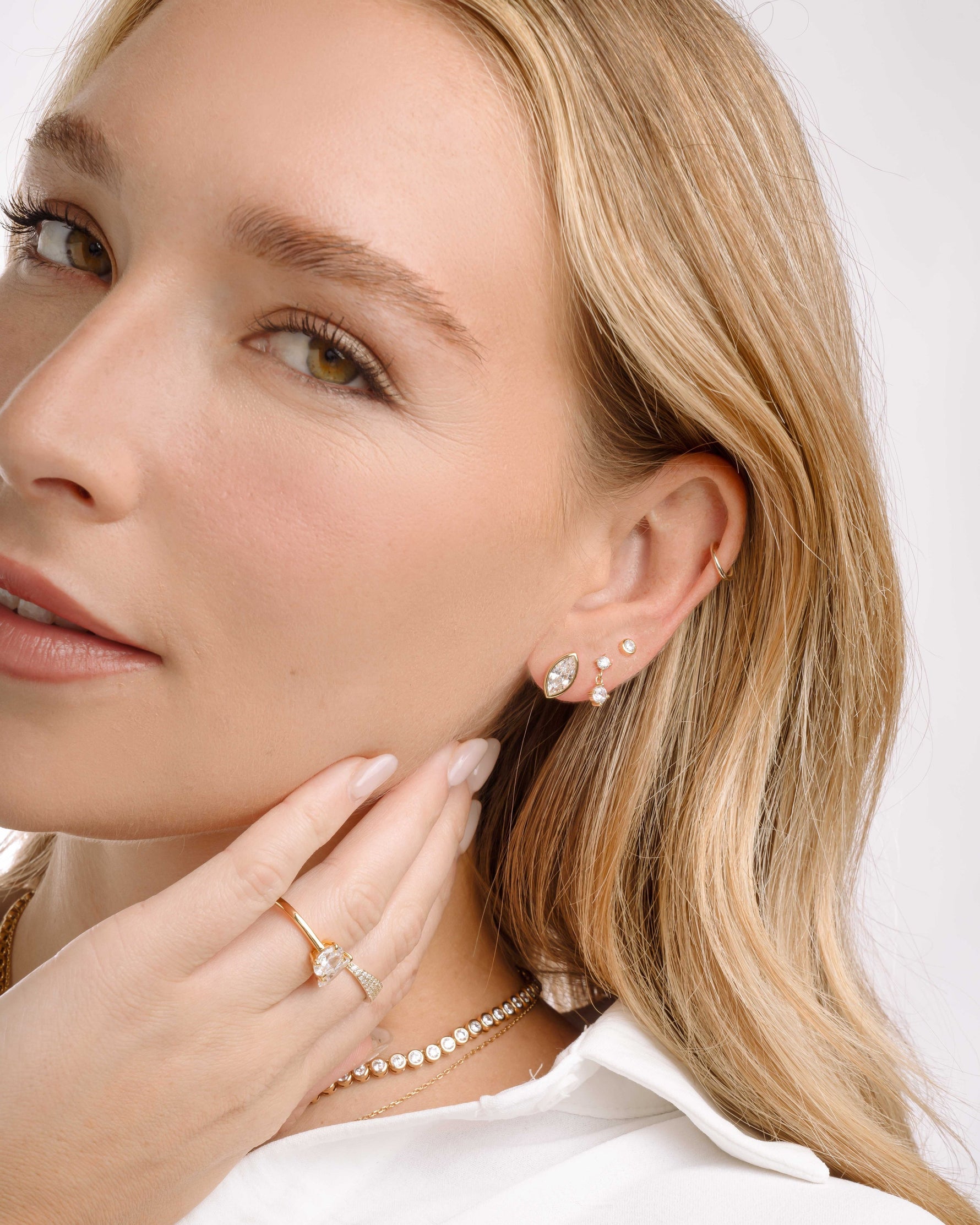 Gold marquise stud earrings, followed my a dangle earring, a basic diamond stud earring, and gold stackable rings