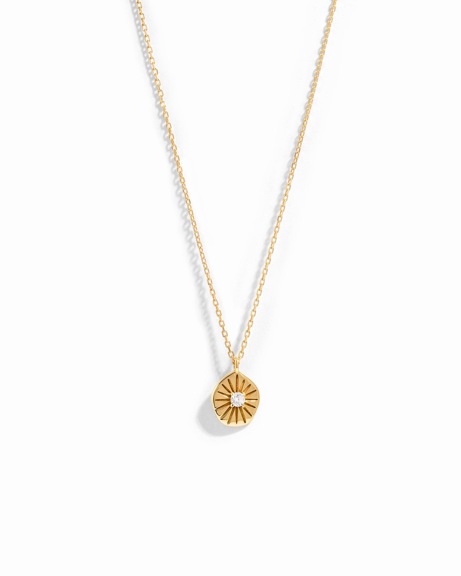gold pendant necklace with sunburst medallion