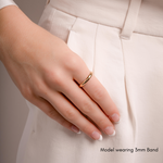 a model's hands showcasing a minimalist gold band measuring 3mm