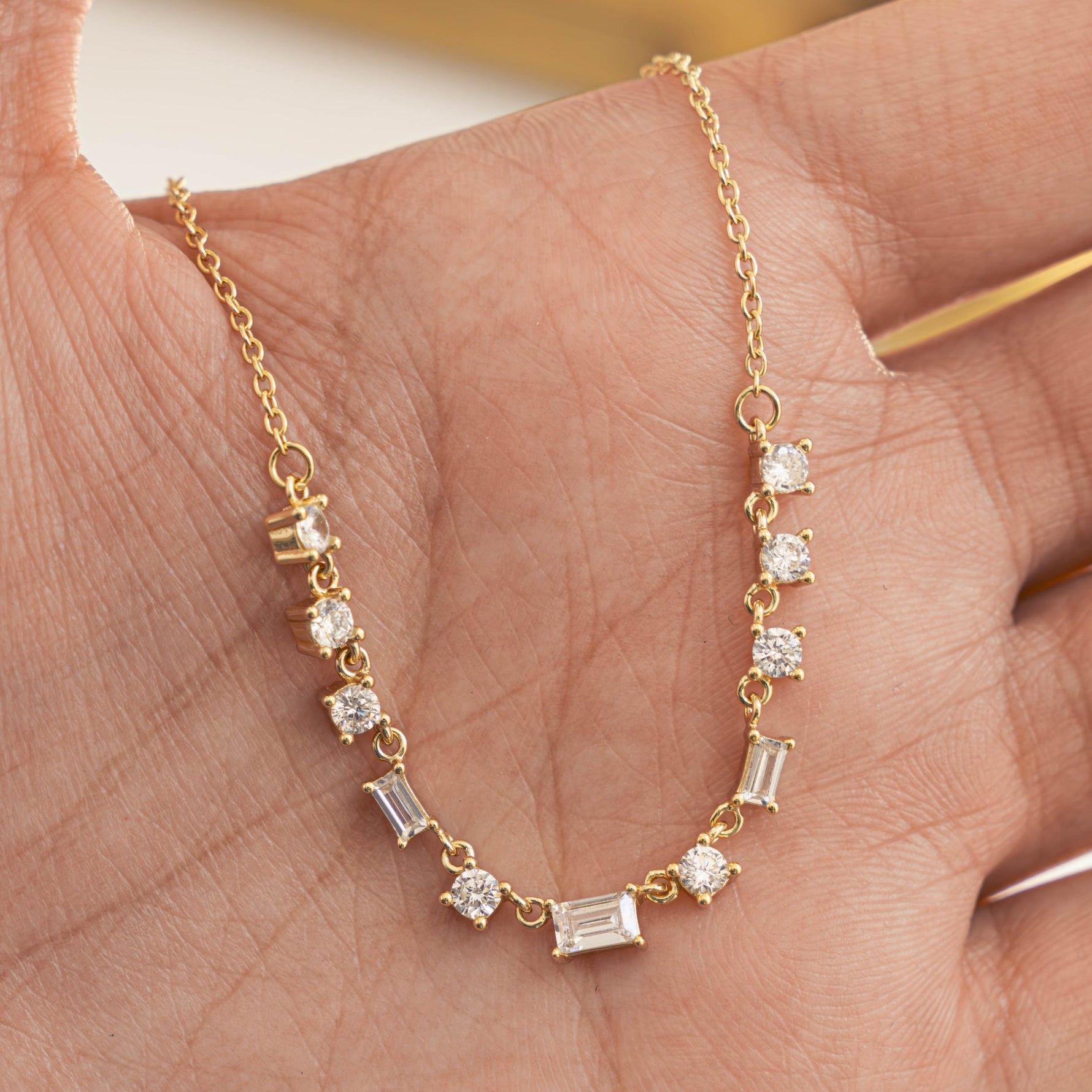 Model holding gold charm necklace with diamonds 
