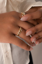 Closeup image of model wearing gold stacking rings including a dainty fluted diamond ring and a minimalist ring for stacking