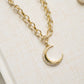 closeup image of gold moon necklace with diamond gold chain