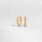 Closeup image of gold diamond huggie earrings