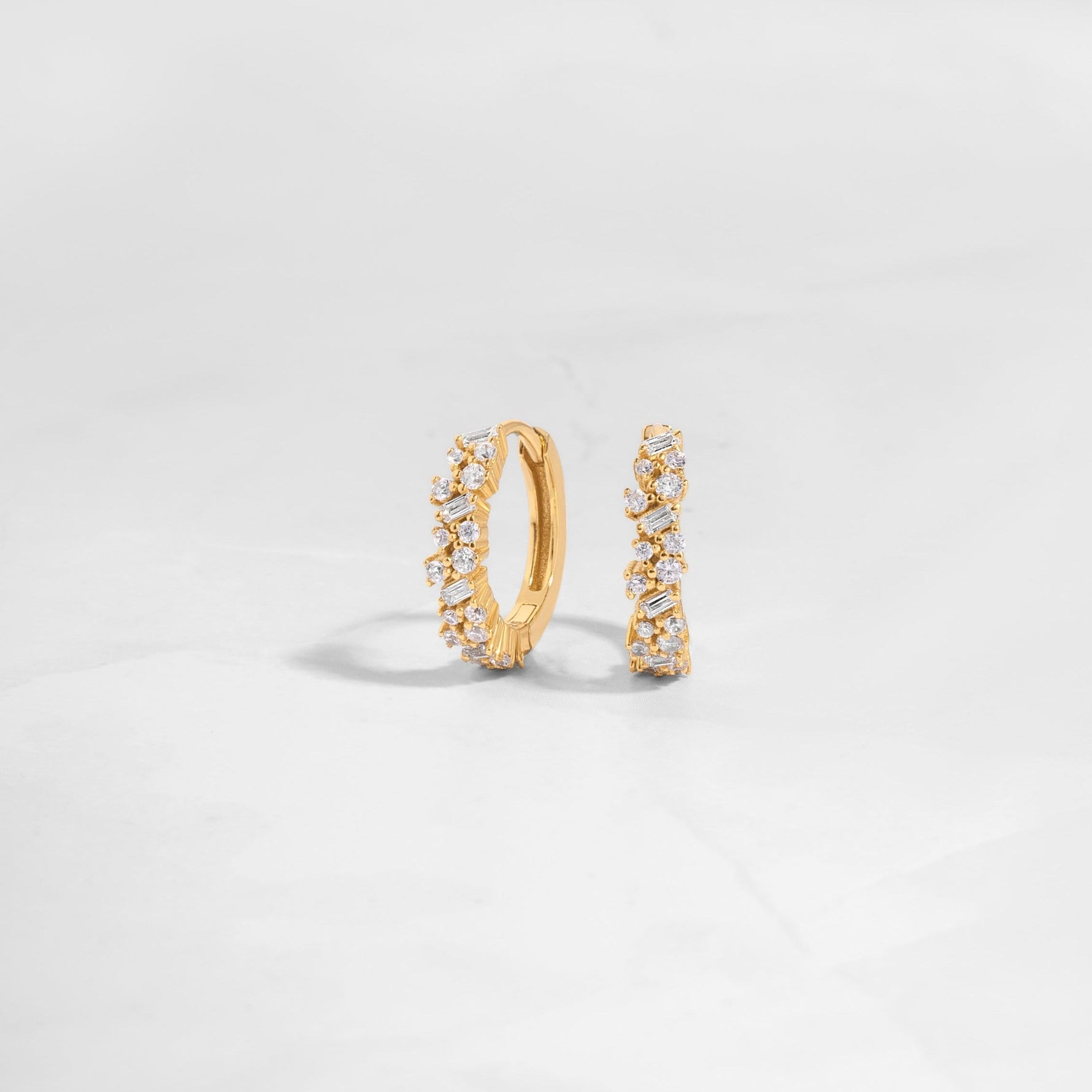 Closeup image of gold diamond huggie earrings